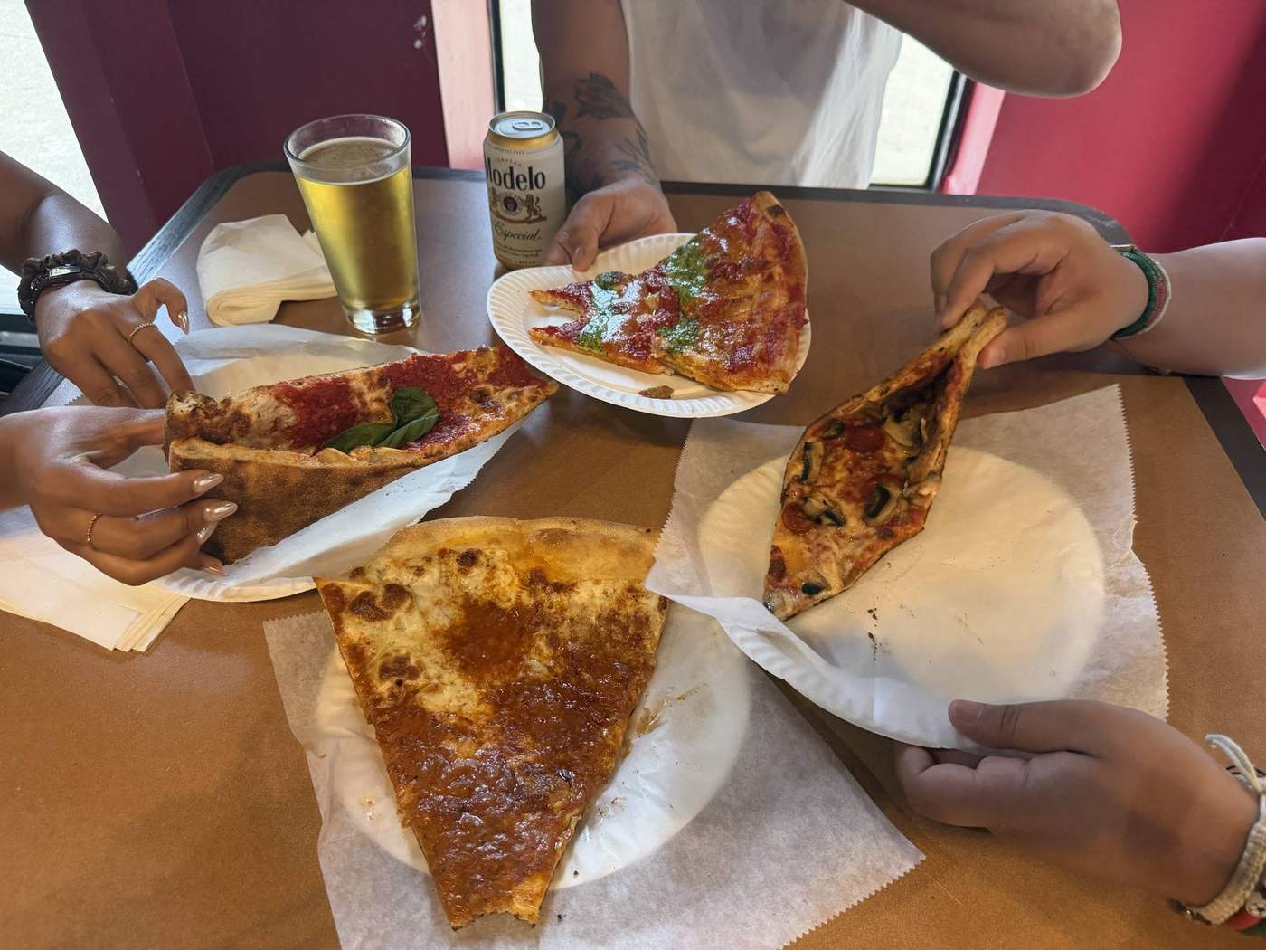 Four people sharing slices at Ray's Corner