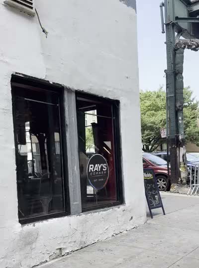 The corner of 215th Street with the Ray's Corner window decal and the sidewalk chalkboard
