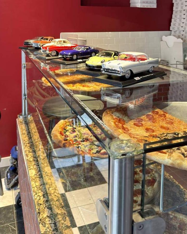 The die-cast classics lined up on top of the pizza case at Ray's Corner, red wall behind, checkered floor below